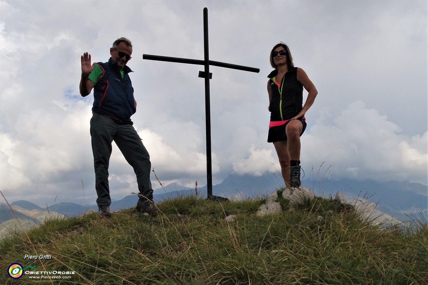 55 Alla croce di vetta della Corna Grande (2089 m) con vista a dx sul Tre Signori avvolto nelle nuvole .JPG